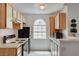 Compact kitchen area featuring bright wood cabinets and updated black appliances at 3150 Soft Breezes Dr # 2046, Las Vegas, NV 89128