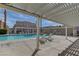 A covered lounge area next to a pool with chairs and tables at 3150 Soft Breezes Dr # 2046, Las Vegas, NV 89128