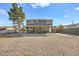 Rear exterior view of home with gravel yard, covered parking area, and mature trees at 3208 Alcoa Ave, Las Vegas, NV 89102
