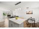 Open floorplan blends kitchen island seating and living room with a modern couch at 3208 Alcoa Ave, Las Vegas, NV 89102