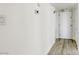 Bright hallway with a clean aesthetic, featuring wood-look flooring and modern light switch and thermostat at 3930 University Center Dr # 311, Las Vegas, NV 89119