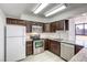 Well-lit kitchen with dark wood cabinets, stainless steel appliances, and granite countertops at 3930 University Center Dr # 311, Las Vegas, NV 89119