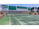 Community tennis court with green surface, net, and secure perimeter fencing at 3930 University Center Dr # 311, Las Vegas, NV 89119