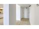 Apartment hallway with tile flooring, white walls, and a glimpse of the kitchen with stainless steel appliances at 3930 University Center Dr # 312, Las Vegas, NV 89119