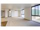 Bright and airy living room with large windows, neutral carpet, and a view into the entryway and kitchen at 3930 University Center Dr # 312, Las Vegas, NV 89119