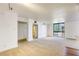 Spacious living room featuring large windows, neutral carpet, and a view of a mirror in the entryway at 3930 University Center Dr # 312, Las Vegas, NV 89119