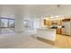 Open living room and kitchen with large windows, carpet and hardwood flooring, and a breakfast bar at 3930 University Center Dr # 312, Las Vegas, NV 89119