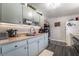 An efficient kitchen featuring pale blue cabinets and wood-look laminate flooring at 4691 Sun Valley Cir, Las Vegas, NV 89122