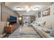 Comfortable living room with a large sectional, wood-look flooring, and a decorative entertainment center at 4691 Sun Valley Cir, Las Vegas, NV 89122