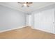 Bright bedroom featuring modern ceiling fan, closet with sliding doors and light hardwood floors at 4998 Rappahanock St, Las Vegas, NV 89122