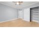 Bright bedroom featuring modern ceiling fan, closet with sliding doors and light hardwood floors at 4998 Rappahanock St, Las Vegas, NV 89122
