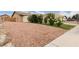 Spacious driveway with desert landscaping of rocks, flowering bushes and green grass at 4998 Rappahanock St, Las Vegas, NV 89122