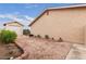 Exterior shot of home and a detached garage with a gravel yard framed by a brick border and desert landscaping at 4998 Rappahanock St, Las Vegas, NV 89122