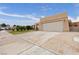 Exterior view of a home featuring a two-car garage, arched entryway, and long driveway, ideal parking at 4998 Rappahanock St, Las Vegas, NV 89122