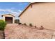 Exterior shot of home and detached garage, with a gravel yard framed by brick, and desert landscaping at 4998 Rappahanock St, Las Vegas, NV 89122