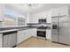 Modern kitchen with stainless steel appliances and light wood-look flooring at 4998 Rappahanock St, Las Vegas, NV 89122