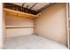 Interior of a storage room with plywood walls, concrete floor, and storage shelves, perfect for organization at 4998 Rappahanock St, Las Vegas, NV 89122