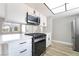 Modern kitchen with white cabinets, stainless steel appliances, and tile backsplash at 508 Van Dornum Ave, Henderson, NV 89011
