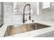 Close up on a stylish, stainless steel kitchen sink with modern faucet and hexagon tile backsplash at 508 Van Dornum Ave, Henderson, NV 89011