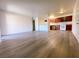 Open-concept living room featuring wood-look floors and bright lighting leading to kitchen at 5321 River Glen Dr # 232, Las Vegas, NV 89103