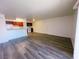 Open-concept living room featuring wood-look floors and bright lighting leading to kitchen at 5321 River Glen Dr # 232, Las Vegas, NV 89103