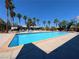 Community pool surrounded by mature palm trees and ample lounge chairs at 5321 River Glen Dr # 232, Las Vegas, NV 89103