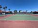 Community tennis court surrounded by a fence with palm trees in the background at 5321 River Glen Dr # 232, Las Vegas, NV 89103