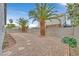 View of the gravel-filled backyard featuring mature palm trees and block wall at 5820 Royal Castle Ln, Las Vegas, NV 89130