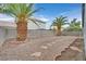Gravel-filled backyard featuring two large palm trees and stepping stone path at 5820 Royal Castle Ln, Las Vegas, NV 89130