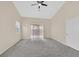 A carpeted bedroom with a ceiling fan and sliding doors to the backyard at 5820 Royal Castle Ln, Las Vegas, NV 89130