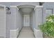 Front entrance with arched porch, white screen door, and flowering plants at 5820 Royal Castle Ln, Las Vegas, NV 89130