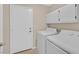 An inside laundry room with washer and dryer and overhead cabinets at 5820 Royal Castle Ln, Las Vegas, NV 89130