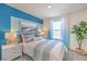 Stylish bedroom featuring colorful accent wall, a modern bed, and natural light at 6109 Aster Garden St # 159, North Las Vegas, NV 89081