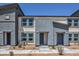 Modern two-story townhome with gray and beige stucco and well manicured landscaping at 6109 Aster Garden St # 159, North Las Vegas, NV 89081