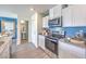 Modern kitchen features stainless steel appliances, granite countertops and sleek white cabinetry at 6109 Aster Garden St # 159, North Las Vegas, NV 89081