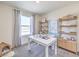 Home office with natural light, white desk and decorative shelving for a functional workspace at 6109 Aster Garden St # 159, North Las Vegas, NV 89081