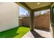 Enclosed backyard has synthetic lawn and brick patio area with covered area at 649 Tranquil Jade St, Las Vegas, NV 89138