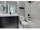 Modern bathroom featuring dark vanity, white fixtures, a shower-over-tub and marble flooring at 649 Tranquil Jade St, Las Vegas, NV 89138