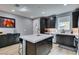 Modern kitchen featuring dark wood cabinets, stainless steel appliances, and an island with white countertop at 649 Tranquil Jade St, Las Vegas, NV 89138