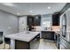 Modern kitchen featuring dark wood cabinets, stainless steel appliances, and an island with white countertop at 649 Tranquil Jade St, Las Vegas, NV 89138