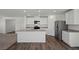 The kitchen features stainless steel appliances, white cabinetry, and an island with a sink at 6772 Violet Cascade Ave, Las Vegas, NV 89156
