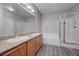 Bathroom featuring dual sinks, granite countertops, and a glass-enclosed shower at 701 Peachy Canyon Cir # 201, Las Vegas, NV 89144