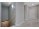 Hallway with neutral paint, leading to stairs and an entrance door, offering a bright and welcoming space at 701 Peachy Canyon Cir # 201, Las Vegas, NV 89144