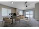 Bright living room features a modern ceiling fan, plush carpet, and sliding door to backyard patio at 701 Peachy Canyon Cir # 201, Las Vegas, NV 89144