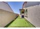 Low maintenance backyard featuring a putting green, synthetic grass, covered patio, and privacy wall at 709 Corelli Cove St, Henderson, NV 89011