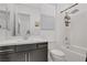 Cozy bathroom featuring a shower-tub, white tile, and a gray modern vanity at 709 Corelli Cove St, Henderson, NV 89011