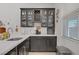 Wet bar with stainless steel sink, white countertops, dark cabinets, and a wine rack at 709 Corelli Cove St, Henderson, NV 89011