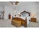 Spacious main bedroom with wood furniture, ceiling fan, carpet, and soft, neutral decor at 709 Corelli Cove St, Henderson, NV 89011
