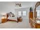 Spacious main bedroom with wood furniture, ceiling fan, carpet, and a large TV at 709 Corelli Cove St, Henderson, NV 89011