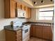 Updated kitchen boasts granite countertops, white appliances, wooden cabinetry, and modern fixtures at 7300 Pirates Cove Rd # 2054, Las Vegas, NV 89145